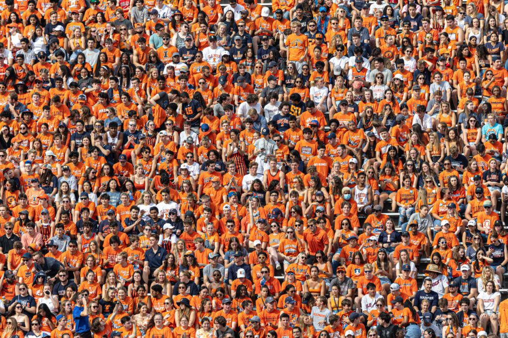 Fans wearing orange in their football stadium seats